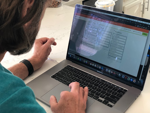 A person sits at a desk with a laptop as they participate in a card sort.